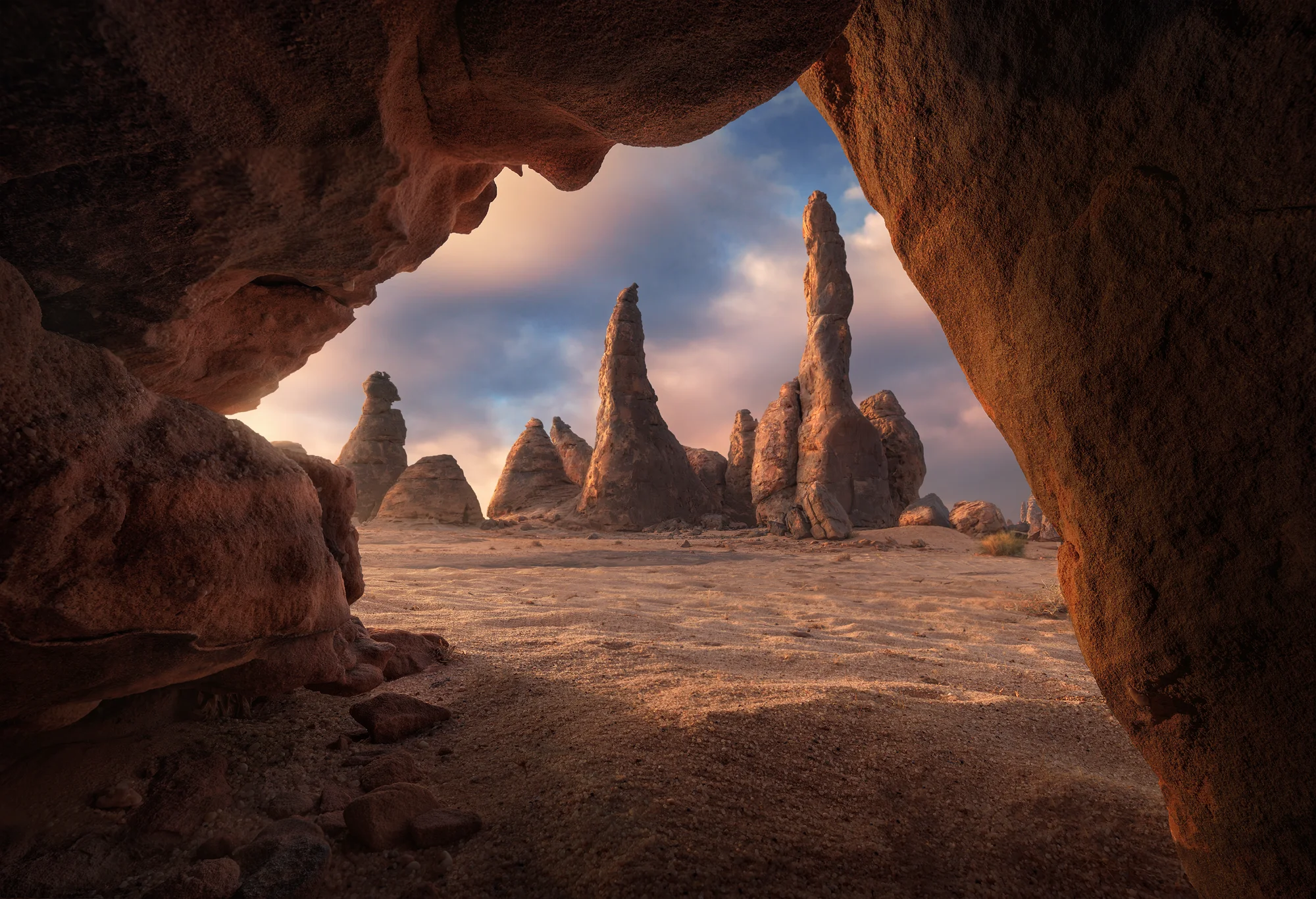 Rock formations framed by a cave at sunrise in AlUla, Saudi Arabia